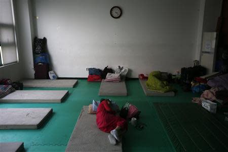 A Korean Chinese woman lies on a mattress at a makeshift camp in Seoul October 14, 2013. REUTERS/Kim Hong-Ji