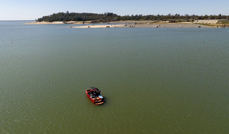 A boat floats in the Granite Bay area of Folsom Lake, in Granite Bay, California on March 26, 2023. 
