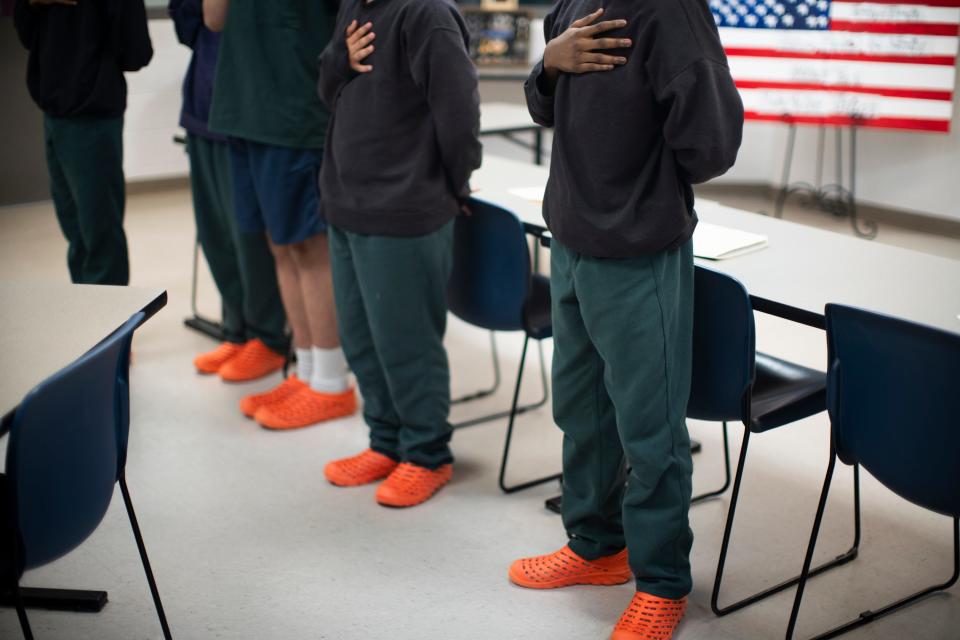 Teenage boys stand for "The Star-Spangled Banner" during a Fourth of July presentation about the armed forces, at Multi-County Juvenile Detention Center in Lancaster.