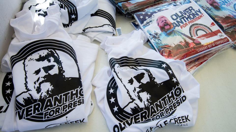 t shirts with oliver anthony on them lay displayed on a table