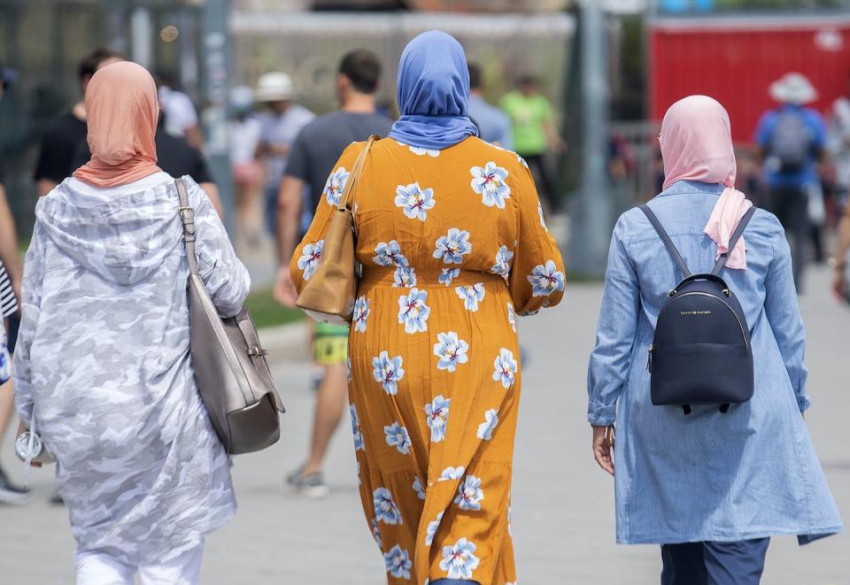 Women wear hijabs as they walk in the Old Port in Montréal in August 2022. As the Québec Court of Appeal prepares to hear in November an appeal of a Bill 21 ruling, a new survey shows religious minorities in Québec are feeling less safe, less accepted and less hopeful since the province passed the law. THE CANADIAN PRESS/Graham Hughes