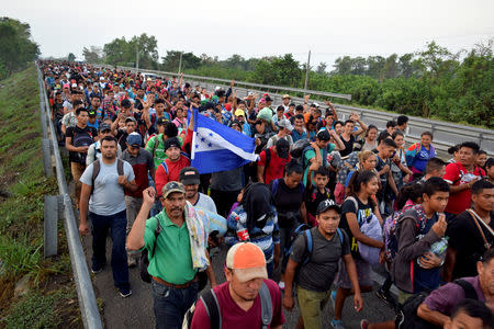 Migrants from Central America and Cuba walk on a highway during their journey towards the United States, in Tuzantan, in Chiapas state, Mexico March 25, 2019. REUTERS/Jose Torres