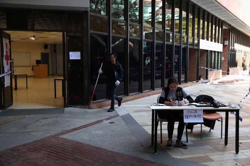 A policewoman sits at a table in front of the evidence area, as members of a safety team established by police and local authorities assess and clear unsafe items, at the Hong Kong Polytechnic University (PolyU) in Hong Kong