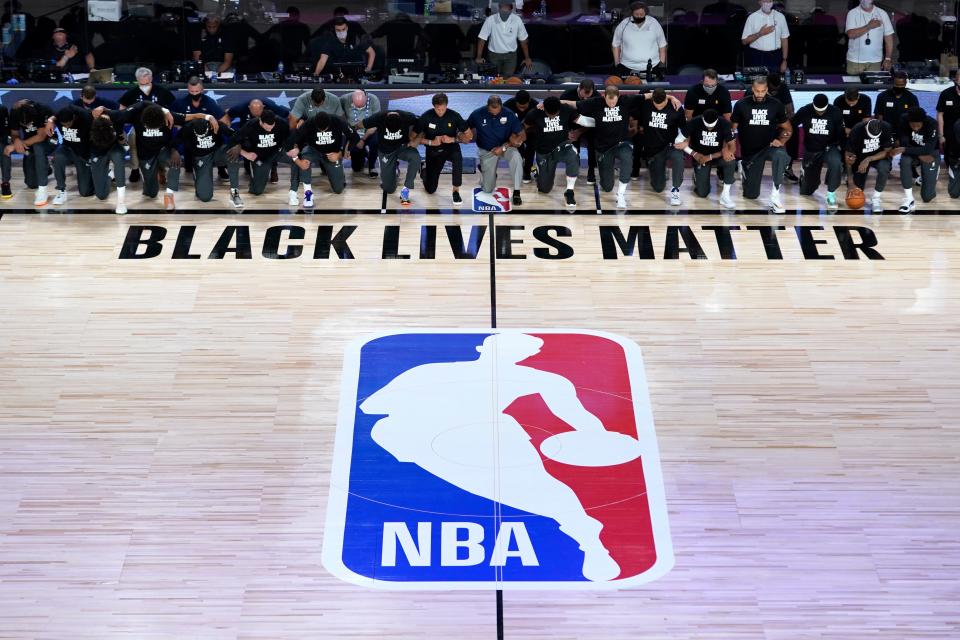 July 30: Players and coaches from the Pelicans and Jazz kneel together around the Black Lives Matter logo during the national anthem before the NBA restart.