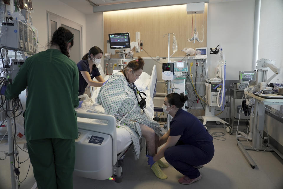 Lisa Pisano steps back into her bed while recovering from her surgeries at NYU Langone Health in New York on Monday, April 22, 2024. Doctors transplanted a pig kidney into Pisano, who was near death, part of a dramatic pair of surgeries that also included a fix for her failing heart. (AP Photo/Shelby Lum)