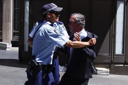 Police push back a member of the public who tried to get into a building located near the Lindt cafe, where hostages are being held, at Martin Place in central Sydney December 15, 2014. REUTERS/David Gray