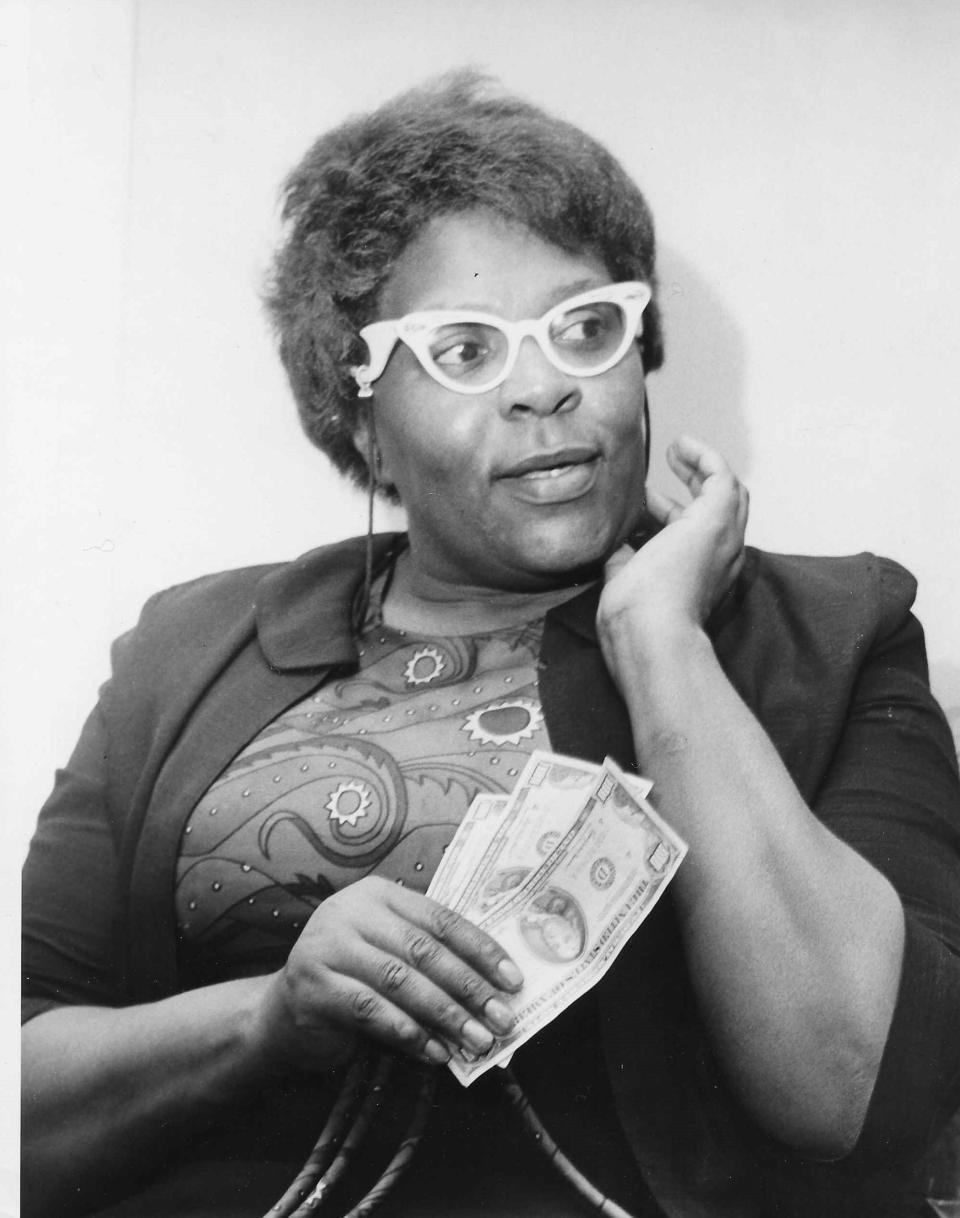 Helen Arnold holds three, crisp $100 bills after the return of a Secret Santa in December 1964.