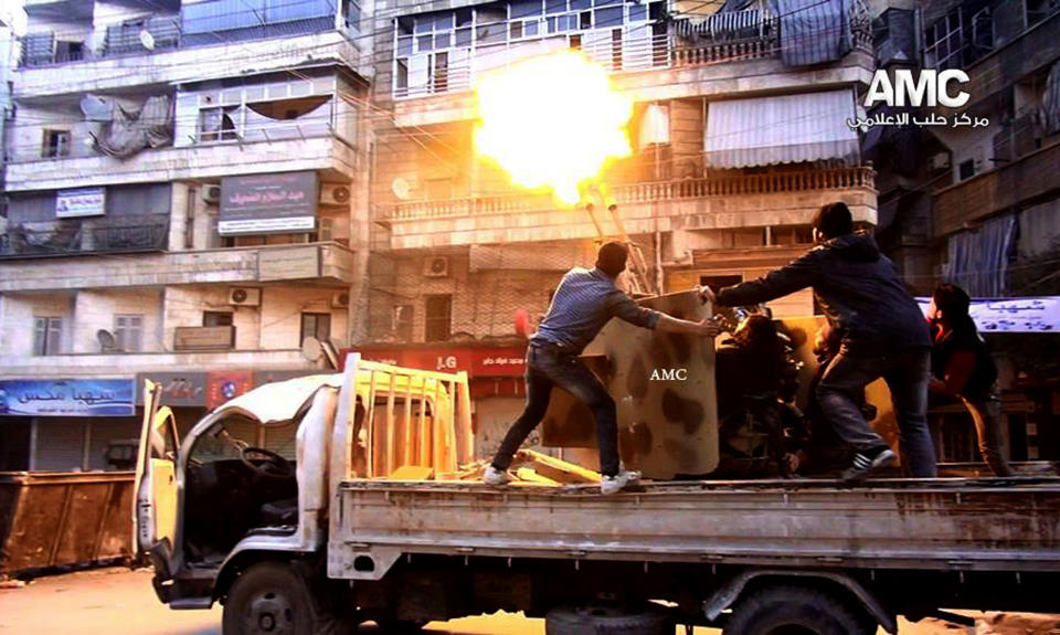 In this Saturday Feb. 1, 2014, photo provided by the anti-government activist group Aleppo Media Center (AMC), which has been authenticated based on its contents and other AP reporting, Syrian rebels fire their anti-aircraft gun at Syrian forces airplanes in Aleppo, Syria. Syrian government helicopters and warplanes unleashed a wave of airstrikes on more than a dozen opposition-held neighborhoods in the northern city of Aleppo on Sunday, in a ferocious attack that killed at least 36 people, including 17 children, activists said. The AMC logo has been inserted in top right corner and the initials AMC appear on weapon. (AP Photo/Aleppo Media Center, AMC)