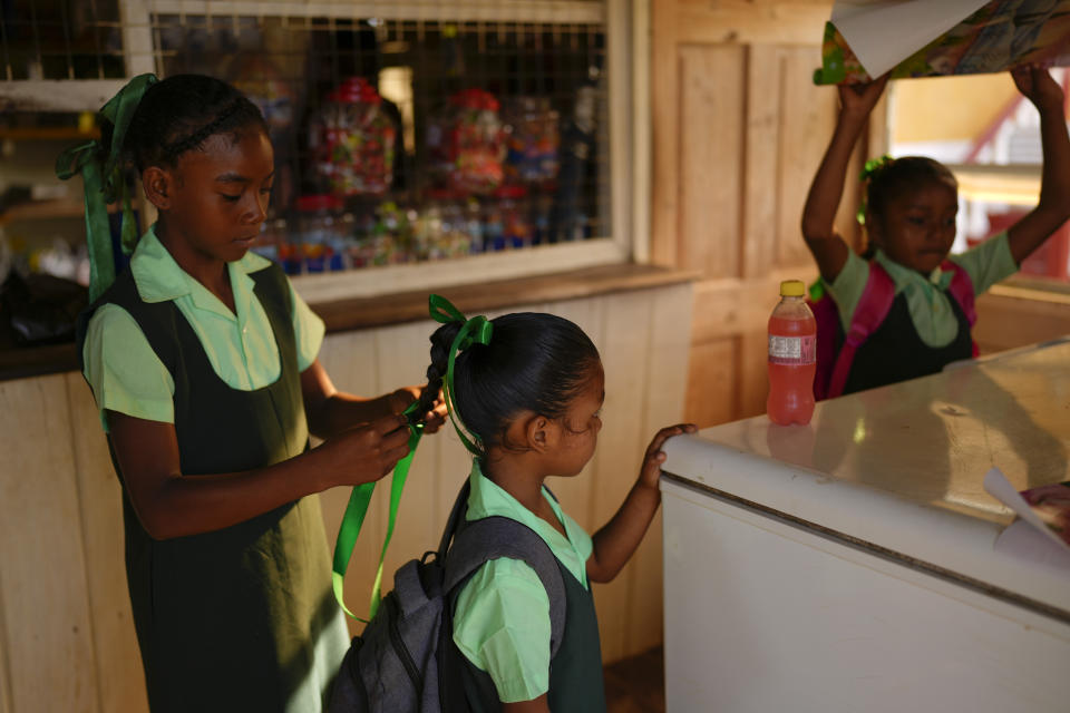 Amerindian children buy school supplies and snacks in Chinese Landing, Guyana, Monday, April 17, 2023. Guyana has some 78,500 Amerindians who represent nearly 10% of the country’s population. They live in more than 240 communities that often are home to large deposits of gold like Chinese Landing. (AP Photo/Matias Delacroix)