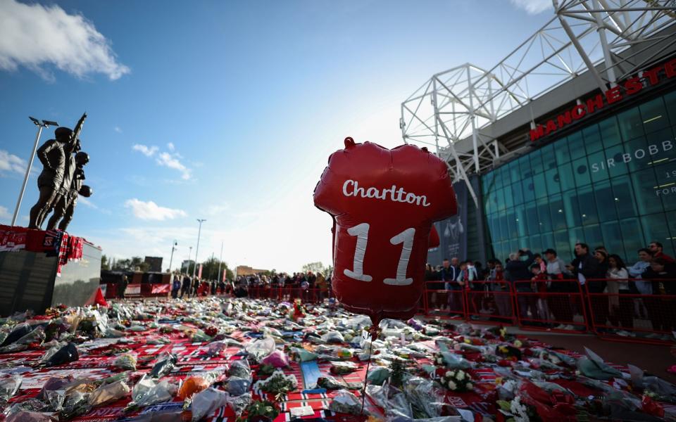 A 'Charlton' balloon rises above the scarves and flowers