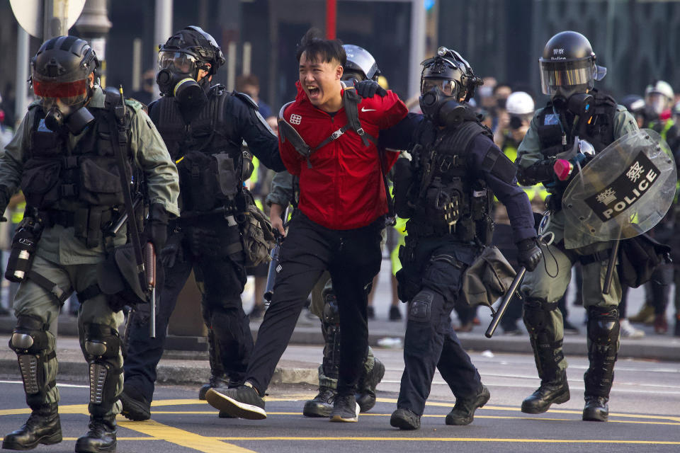 A pro-democracy protester shouts after being detained by policemen during a rally in Hong Kong, Sunday, Dec. 1, 2019. A huge crowd took to the streets of Hong Kong on Sunday, some driven back by tear gas, to demand more democracy and an investigation into the use of force to crack down on the six-month-long anti-government demonstrations. (AP Photo/Ng Han Guan)