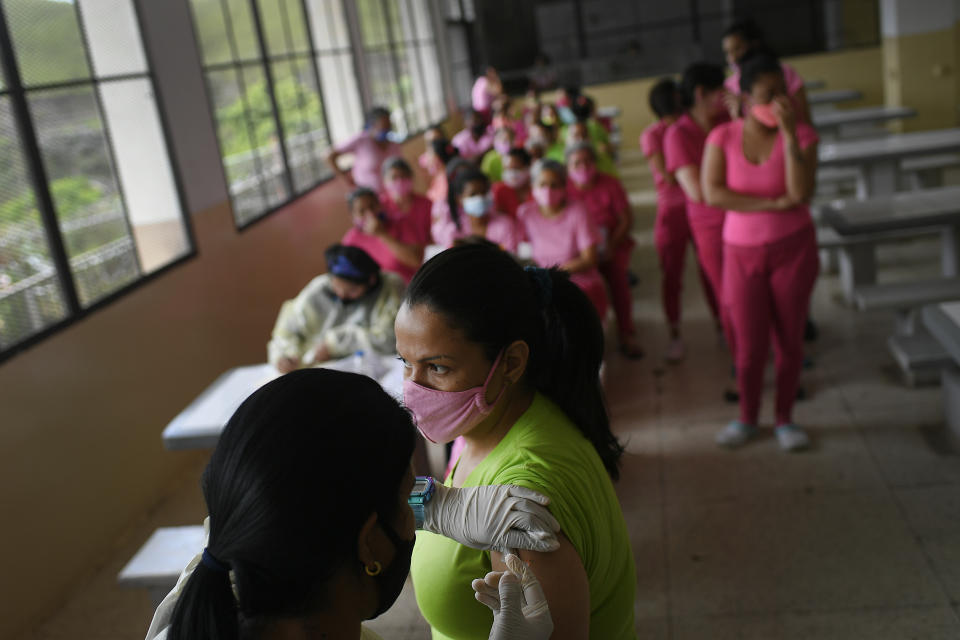 A healthcare worker inoculates an inmate with a dose of the Sinopharm COVID-19 vaccine during a vaccination campaign at the women's prison in Los Teques, Miranda state, Venezuela, Friday, July 2, 2021. (AP Photo/Matias Delacroix)