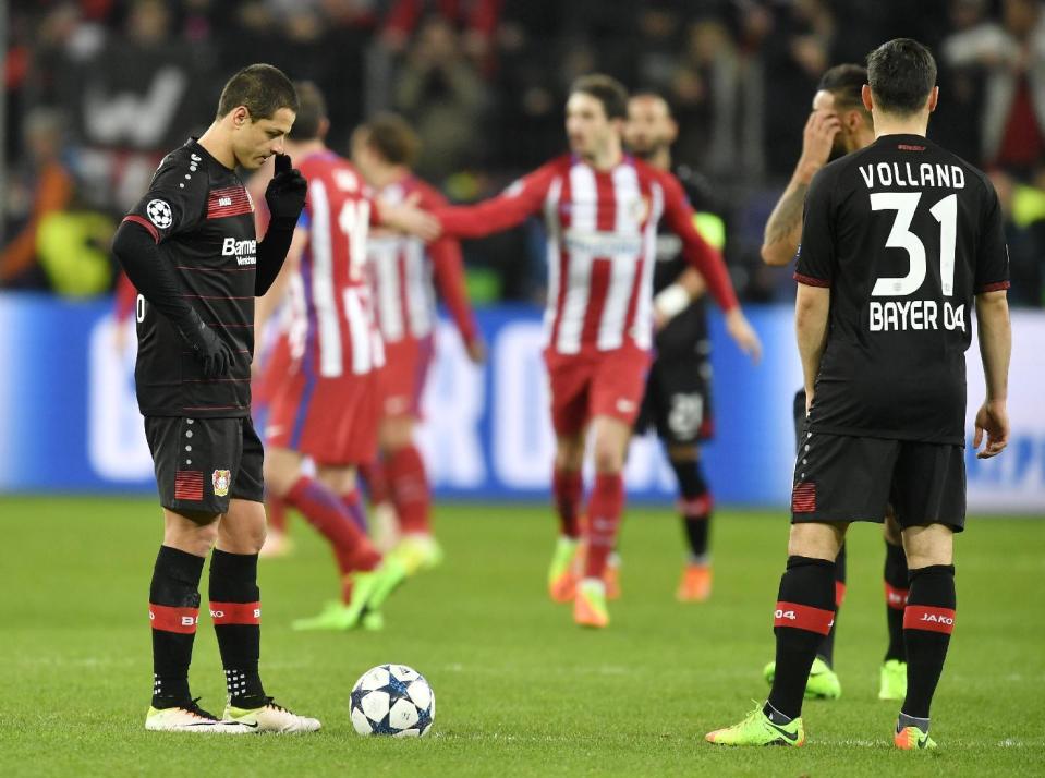 Javier Hernández (izquierda) de Bayer Leverkusen se toca la nariza luego que el Atlético de Madrid anotara un gol en el partido por los octavos de final de la Liga de Campeones, el martes 21 de febrero de 2017. (AP Foto/Martin Meissner)