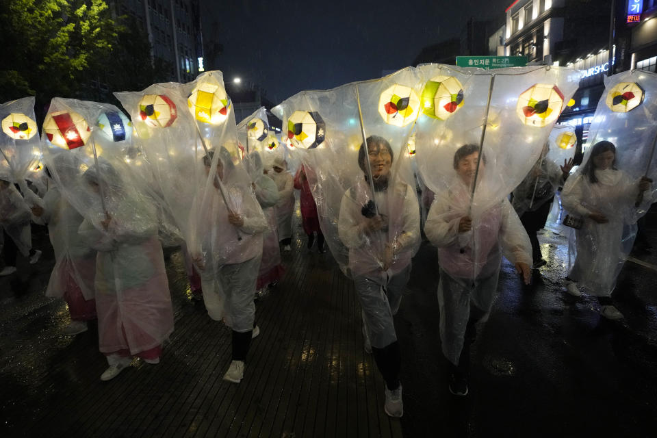 Buddhists participate in a lantern parade, wrapped in plastic sheets to protect from the rain, during the Lotus Lantern Festival, ahead of the birthday of Buddha at Dongguk University in Seoul, South Korea, Saturday, May 11, 2024. (AP Photo/Ahn Young-joon)