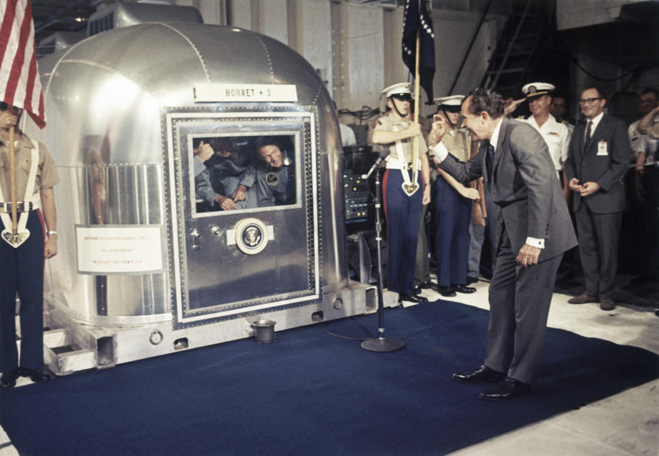 FILE - In this July 24, 1969 file photo, President Richard Nixon gives an "OK" sign as he greets Apollo 11 astronauts Neil Armstrong, Michael Collins, and Buzz Aldrin in a quarantine van aboard the USS Hornet after splashdown and recovery in the Pacific Ocean. (AP Photo)