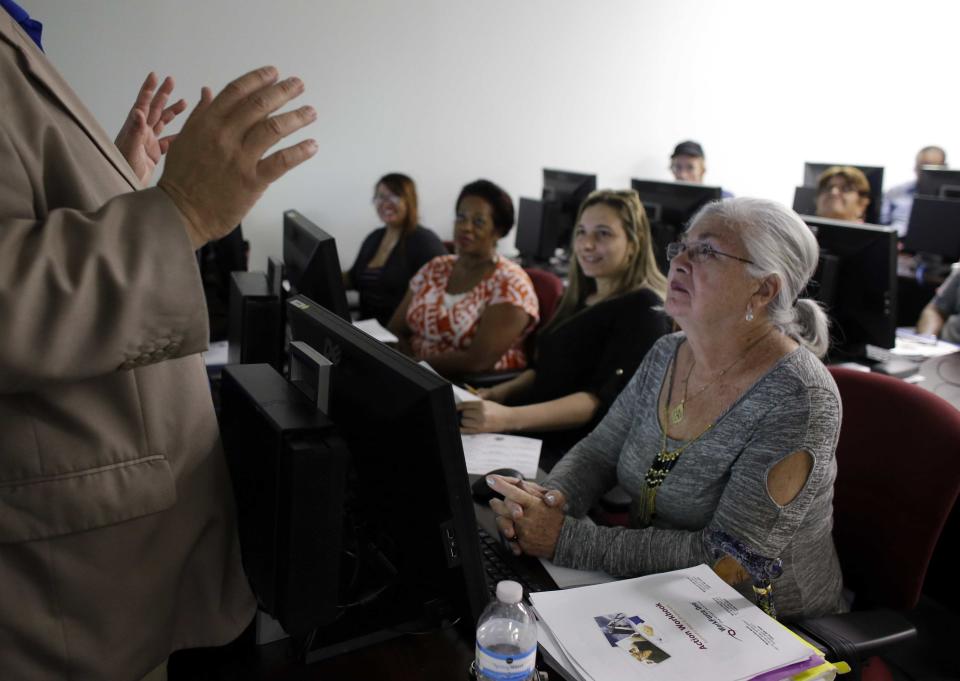 In this Thursday, Feb. 6, 2014, photo, Rosi Pozzi, 73, of Davie, Fla., right, listens during a job search workshop at WorkForce One, in Davie, Fla. Two straight weak job reports have raised doubts about economists’ predictions of breakout growth in 2014. The global economy is showing signs of slowing again. (AP Photo/Lynne Sladky)