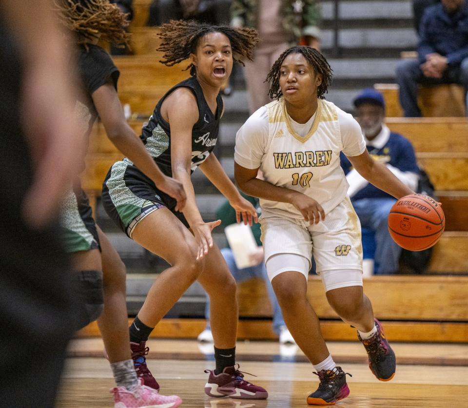 Warren Central High School senior Denyha Jacobs (10) drives the ball around the defense of Indianapolis Arsenal Technical High School junior Adrianna Thompkins (32) during the first half of an IHSAA Class 4A Sectional semi-final basketball game, Friday, Feb. 2, 2024, at Cathedral High School.