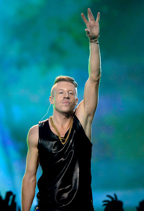 Rapper Macklemore performs his hit 'This Is The Moment' on stage at the MTV Movie Awards.