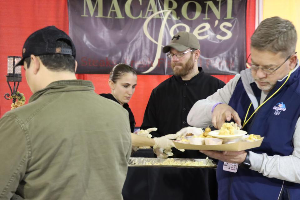 Stephanie Pendergraft and Jeremy Grant serve up a lobster mac and cheese for the Hope and Healing Place's annual The Big Cheese macaroni and cheese competition at the Rex Baxter Building Friday evening.