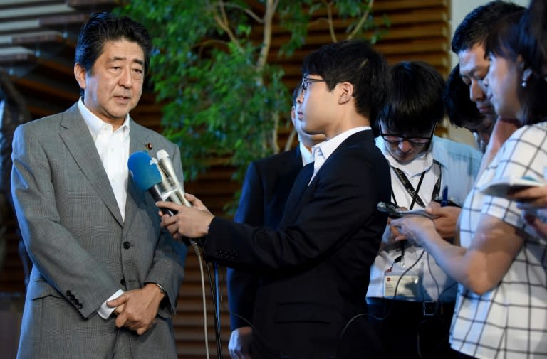 Japan's Prime Minister Shinzo Abe (L) speaks to journalists upon his arrival at his office in Tokyo on September 9, 2016 following news of North Korea's fifth nuclear test