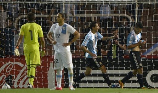 El delantero de Argentina Sergio Agûero (D) celebra tras anotar el segundo gol ante Uruguay en duelo de 9ª fecha de las eliminatorias sudamericanas al Mundial 2014 en el estadio Malvinas Argentinas en Mendoza, a unos 1050 km al oeste de Buenos Aires, el 12 de octubre de 2012. Argentina ganó 3-0 y lidera las eliminatorias. (AFP | juan mabromata)