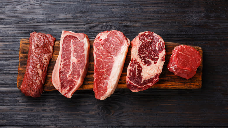 assortment of steaks on wood