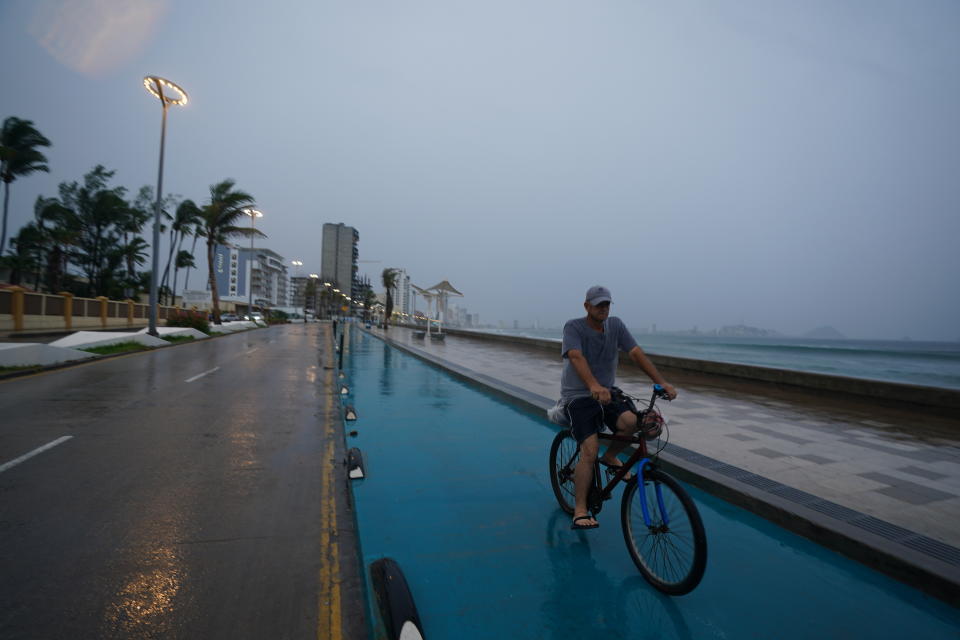 A cyclist rides along the coast in Mazatlan, Mexico, early Monday, Oct. 3, 2022, as Hurricane Orlene approaches. The storm is heading for Mexico's northwest Pacific coast between Mazatlan and San Blas. (AP Photo/Fernando Llano)