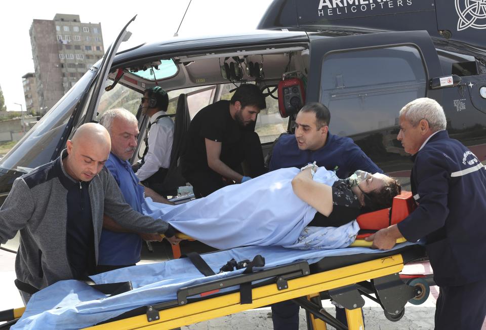 Paramedics and employees of Armenian helicopters company transport a sick woman from Nagorno-Karabakh from Goris to the Erebuni Medical Center in Yerevan, Armenia, Friday, Sept. 29, 2023. Armenian officials say more than 70% of Nagorno-Karabakh's original population have fled the region for Armenia. (Hayk Baghdasaryan, PHOTOLURE via AP)