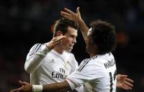 Real Madrid's Gareth Bale (L) celebrates his goal against Real Valladolid with teammate Marcelo during their Spanish First Division soccer match at Santiago Bernabeu stadium in Madrid November 30, 2013. REUTERS/Susana Vera