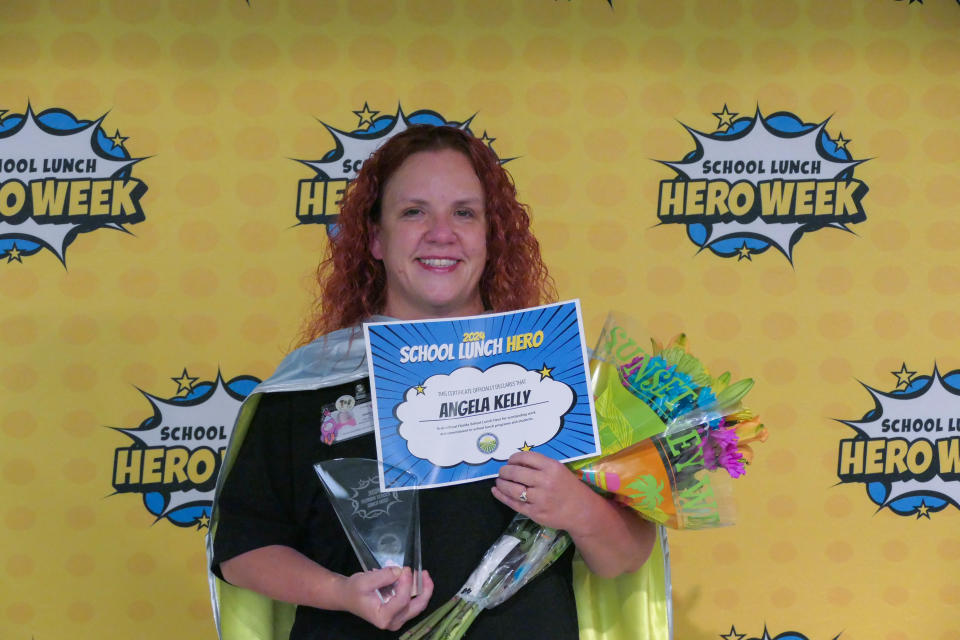 Angela Kelly, one of five recipients of the 2024 Florida School Lunch Heroes award, poses with a certificate. The surprise award ceremony was held in the cafeteria at Lawton Chiles Elementary in Gainesville, Fla. on May 6, 2024.