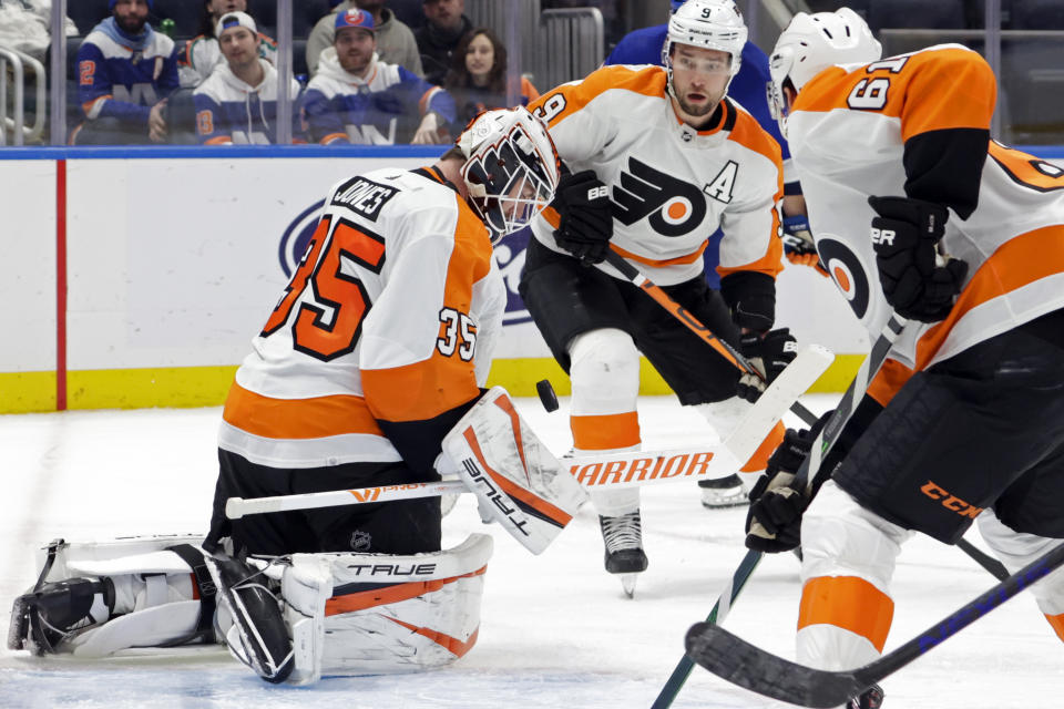 Philadelphia Flyers goaltender Martin Jones (35) blocks a shot as defensemen Ivan Provorov (9) and Justin Braun (61) look on during the second period of an NHL hockey game against the New York Islanders, Tuesday, Jan. 25, 2022, in Elmont, N.Y. (AP Photo/Corey Sipkin)