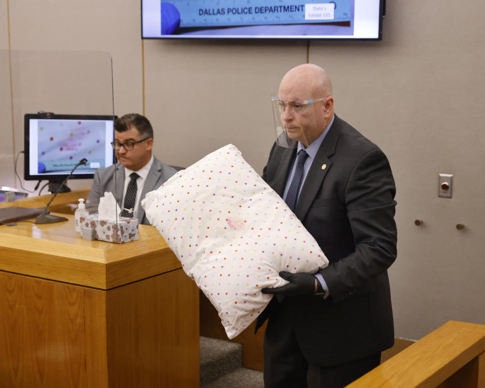 Prosecutor Glen Fitzmartin shows a lipstick stained pillow to the court after showing the evidence to Dallas Police detective Cayce Shelton during the murder trial of Billy Chemirmir at the Frank Crowley Courts Building in Dallas, Tuesday, Nov. 16, 2021. Chemirmir faces life in prison without parole if convicted of capital murder in the death of 81-year-old Lu Thi Harris. (Tom Fox/The Dallas Morning News via AP, Pool)