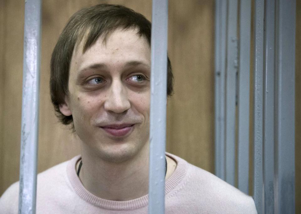 FILE - In this Tuesday Dec. 3, 2013 file photo, Pavel Dmitrichenko stands inside a barred enclosure at a courtroom in Moscow, Russia. A Moscow appeals court has lightened the prison sentences handed down to a Bolshoi dancer and two accomplices for their roles in an acid attack on the ballet’s artistic director. Dancer Pavel Dmitrichenko was convicted in December of organizing the attack and sentenced to six years in prison. The Moscow City Court on Thursday, March 6, 2014, reduced his sentence by six months. (AP Photo/Alexander Zemlianichenko, file)