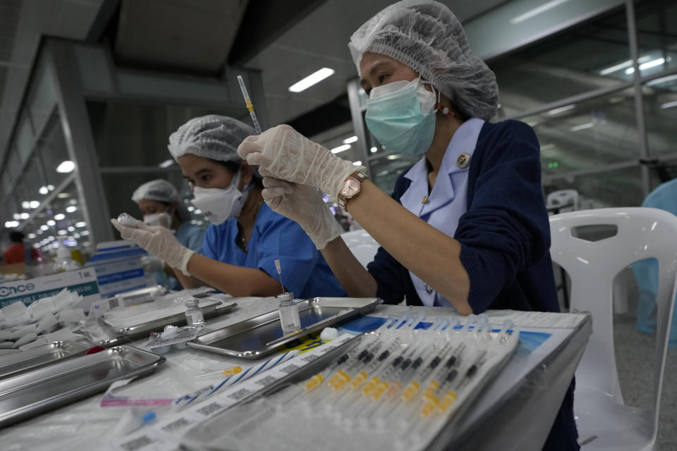 Health workers prepare shots of the AstraZeneca COVID-19 vaccine for people at the Central Vaccination Center in Bangkok, Thailand, Thursday, July 15, 2021. As many Asian countries battle against a new surge of coronavirus infections, for many their first, the slow-flow of vaccine doses from around the world is finally picking up speed, giving hope that low inoculation rates can increase rapidly and help blunt the effect of the rapidly-spreading delta variant. (AP Photo/Sakchai Lalit)