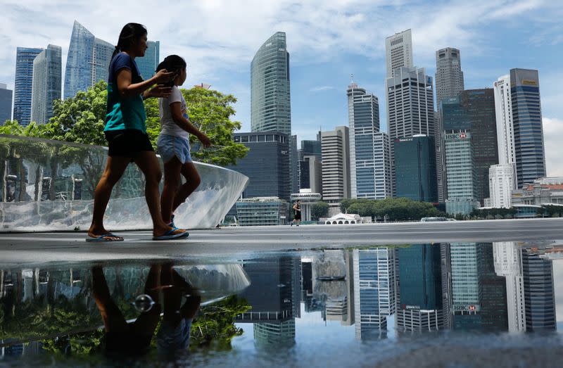 FILE PHOTO: People pass the skyline of Singapore