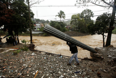 A man recovers some zinc sheets after a mudslide damaged their homes during heavy rains by Tropical Storm Nate in San Jose, Costa Rica October 5, 2017. REUTERS/Juan Carlos Ulate