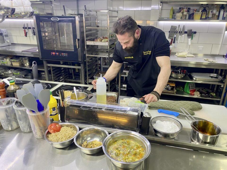 Chef Ivan Kozyr at work in the kitchen of the restaurant he co-owns, Svitlo Café, in Dnipro, central Ukraine. / Credit: Erin Lyall/CBS News