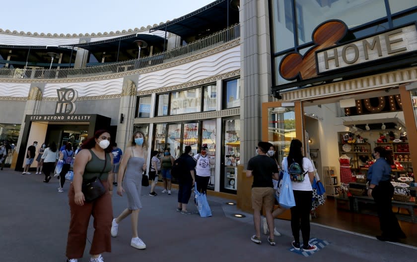 ANAHEIM, CALIF. - JULY 9, 2020. Visitors wait in a long iine to access a shop as Downtown Disney reopens on Thursday, July 9, 2020. Officials required visitors to wear face coverings and practice social distancing. By 5:00 p.m. security guards closed the parking gate, saying that the shopping and dining complex had reached its capacity. Disney''s adjacent them parks remain closed. (Luis Sinco/Los Angeles Times)