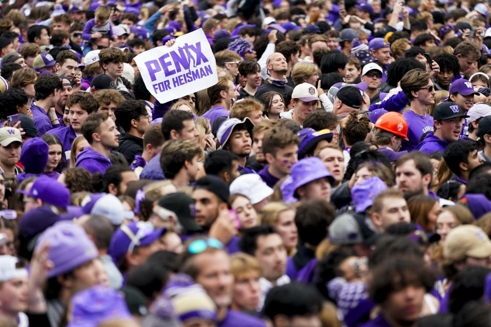 A fan holds a sign for Washington quarterback Michael Penix Jr. to receive the Heisman trophy following Washington's 36-33 victory over Oregon in an NCAA college football game, Saturday, Oct. 14, 2023, in Seattle. (AP Photo/Lindsey Wasson)