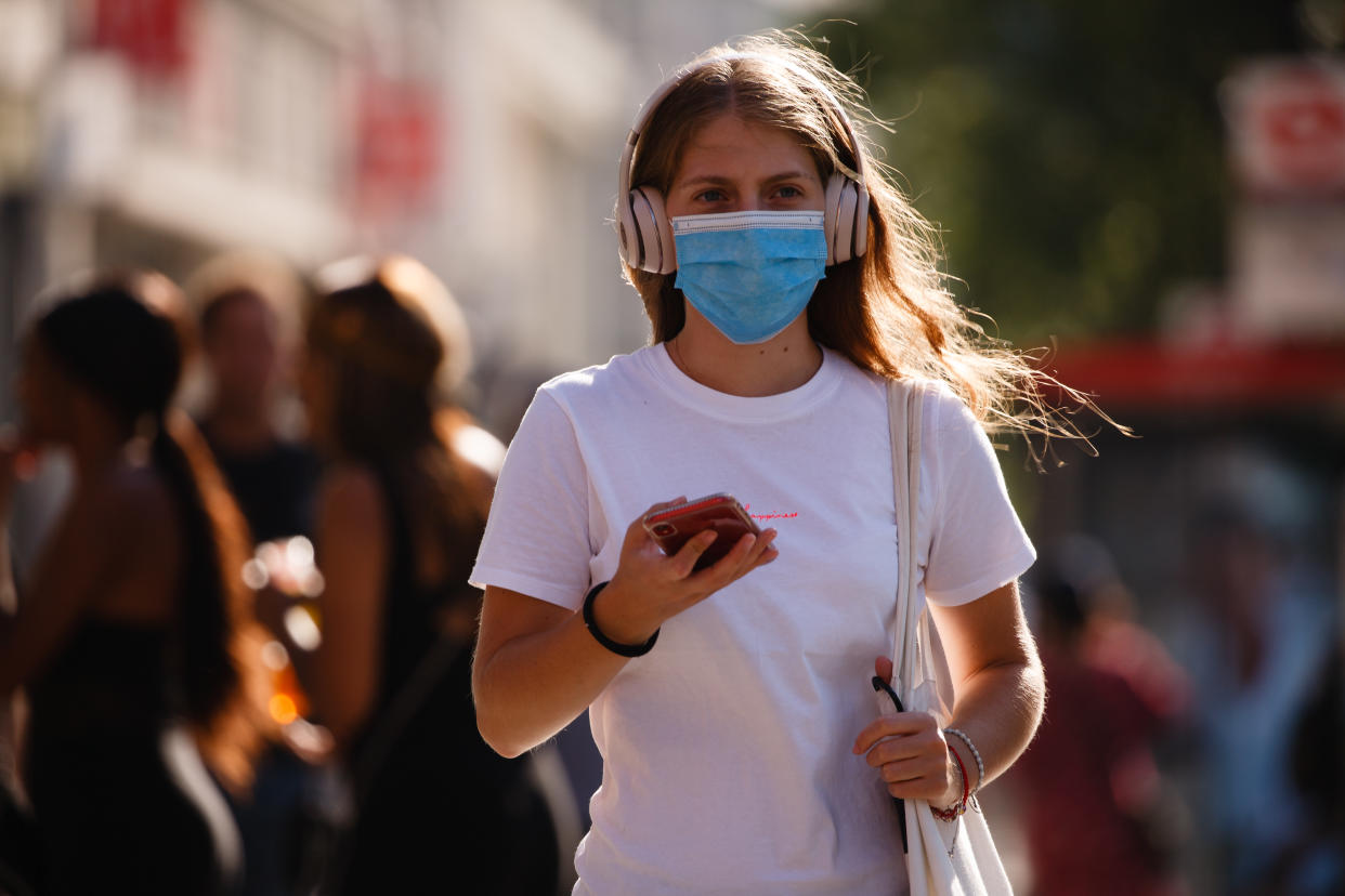 A woman wearing a face mask waits at a pedestrian crossing on Oxford Street in heatwave conditions in London, England, on June 25, 2020. Temperatures rose to 33C in parts of London today, in what has been one of the UK's hottest days of the year so far. Central London was nonetheless busy with shoppers this afternoon as the retail sector mounts its comeback after coronavirus lockdown restrictions on non-essential shops were eased at the beginning of last week. Among retailers, confidence is reportedly low that recovery will be swift, however, with a survey from the Confederation of British Industry (CBI) today revealing fears of reduced consumer demand as well as operational challenges such as staff absences and transport difficulties. (Photo by David Cliff/NurPhoto via Getty Images)