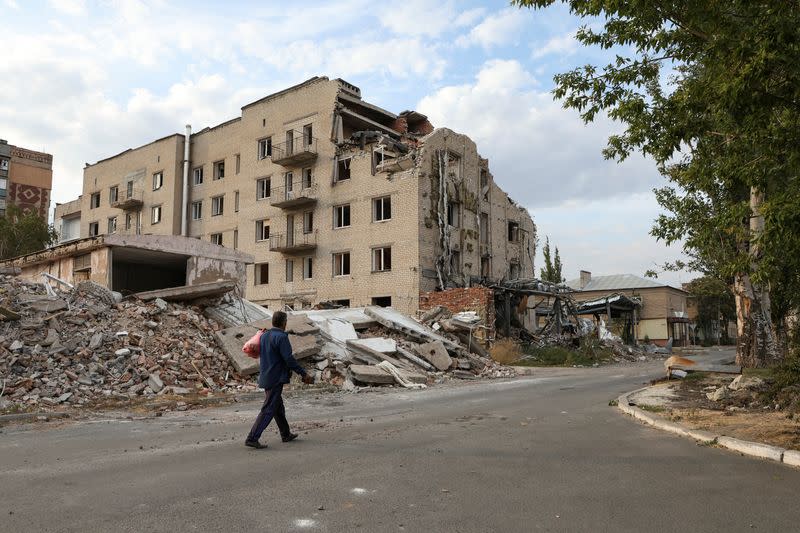 Man walks past a building damaged by a Russian military strike in seen in the town of Pokrovsk