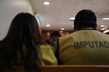 A lawyer talks to his clients, alleged people-trafficking gang members, at a court near the Chilean and Peruvian border, in Arica, Chile, November 16, 2018. REUTERS/Ivan Alvarado