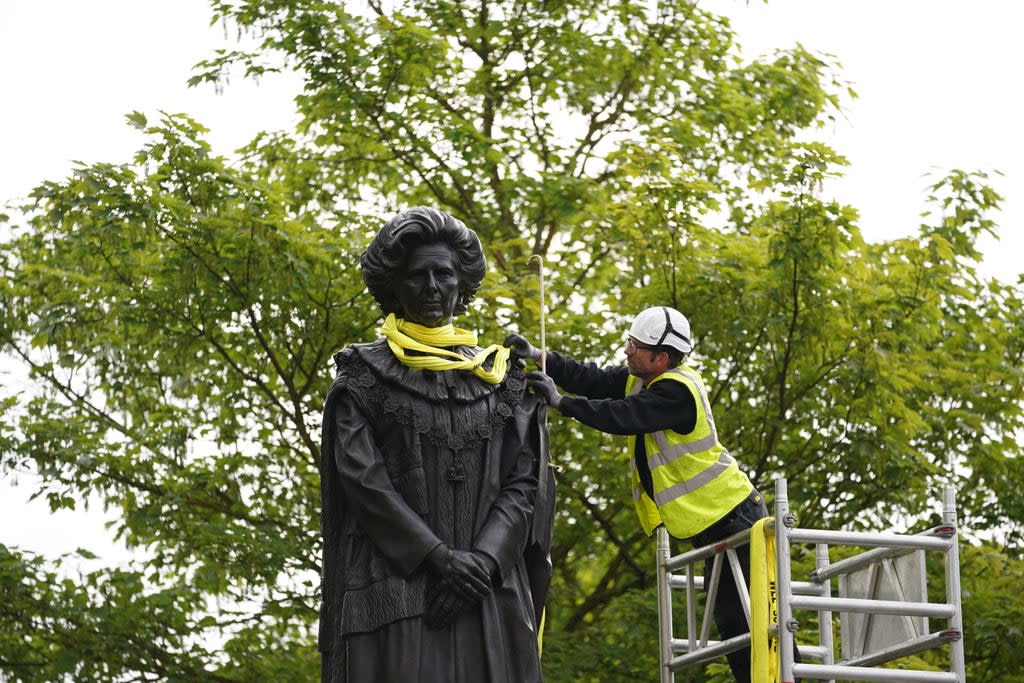 A worker removes the lifting straps from the newly installed statue of Baroness Thatcher in her home town of Grantham, Lincolnshire. Picture date: Sunday May 15, 2022. (PA Wire)