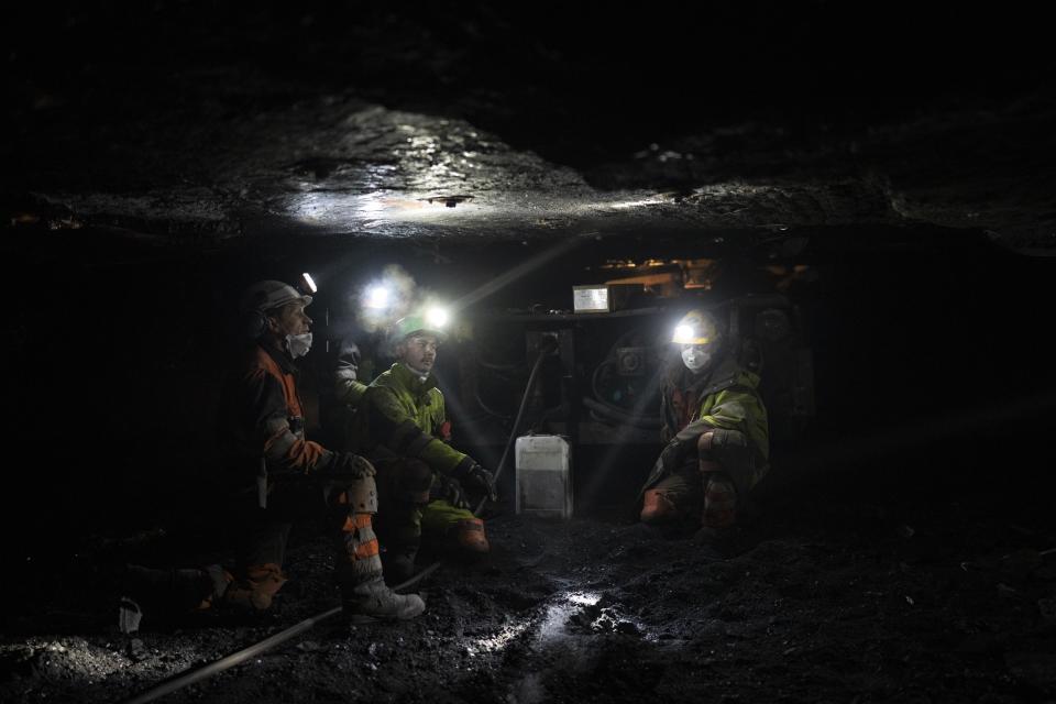 Mineros rellenan una máquina con petróleo al fondo de la mina de carbón Gruve 7 en Adventdalen, Noruega, el lunes 9 de enero de 2023. (AP Foto/Daniel Cole)