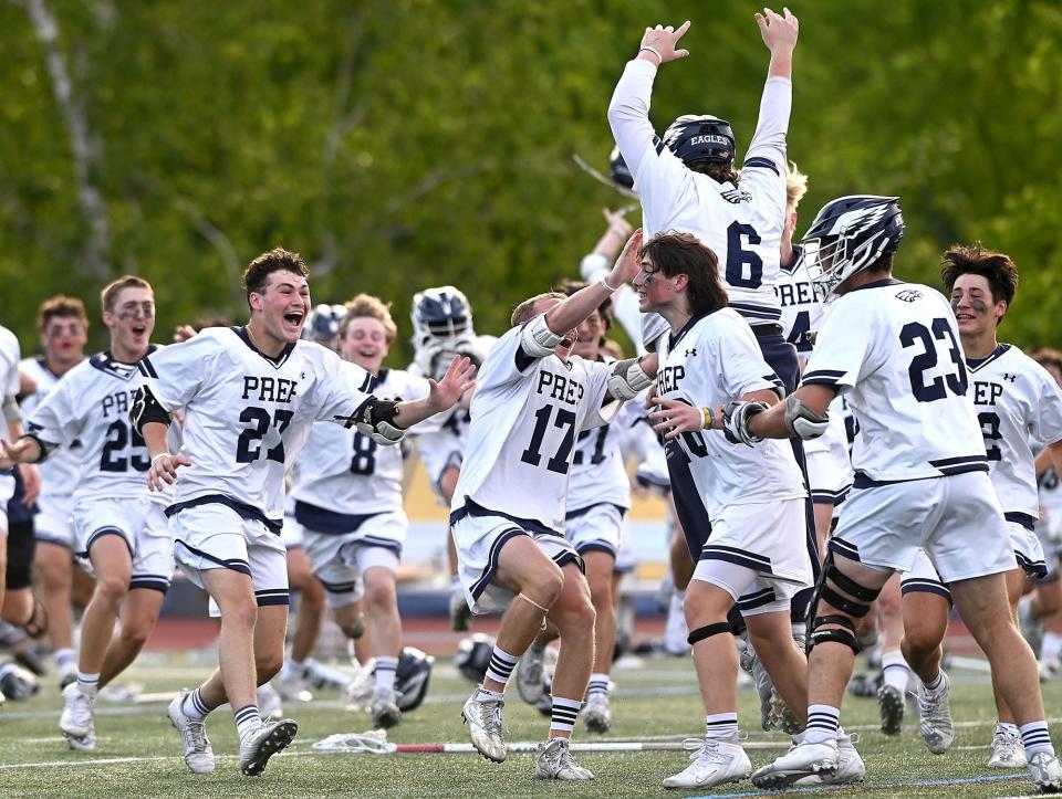 St. John's Prep players celebrate after defeating BC High 11-5 for the MIAA Division 1 boys lacrosse state championship at Worcester State University, June 21, 2022.