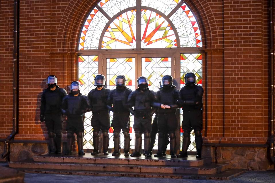 Riot police block an entrance of a church during a Belarusian opposition supporters rally at Independence Square in Minsk, Belarus, Wednesday, Aug. 26, 2020. Protests demanding the resignation of Belarus' authoritarian President Alexander Lukashenko have entered their 18th straight day on Wednesday. (AP Photo/Dmitri Lovetsky)