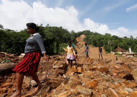 People walk through a landslide site during a rescue mission in Athwelthota village, in Kalutara, Sri Lanka May 28, 2017. REUTERS/Dinuka Li