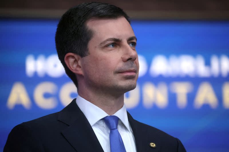 FILE PHOTO: Secretary of Transportation Pete Buttigieg listens as U.S. President Biden speaks about the airline industry at the White House in Washington, U.S.