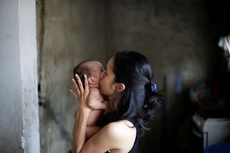 Yennifer Padron kisses her baby in her house at Petare slum in Caracas, Venezuela, August 21, 2017. REUTERS/Andres Martinez Casares/Files