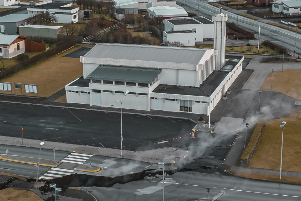 This image taken with a drone shows cracks on the road next to a church in the town of Grindavik, Iceland, Thursday, Nov. 16, 2023. Residents of a fishing town in southwestern Iceland have left their homes after increasing concern about a potential volcanic eruption caused civil defense authorities to declare a state of emergency in the region. Iceland's Meteorological Office says police decided to evacuate Grindavik after recent seismic activity in the area moved south toward the town. (AP Photo/Bjorn Steinbekk)